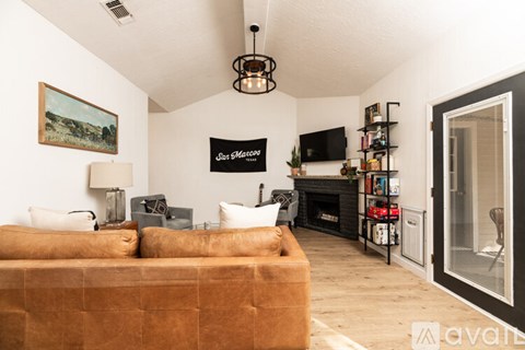 A living room with a couch, a fireplace, and a painting on the wall.