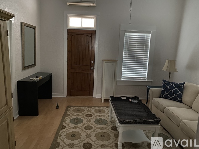 A living room with a couch, coffee table, and rug.
