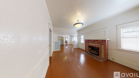 A long hallway with a fireplace and a window.