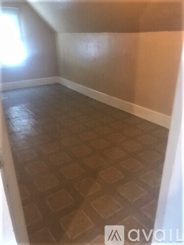 A room with a tiled floor and a window letting in light.