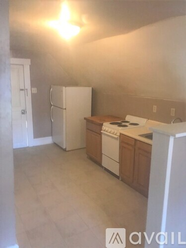A kitchen with white appliances and wooden cabinets.