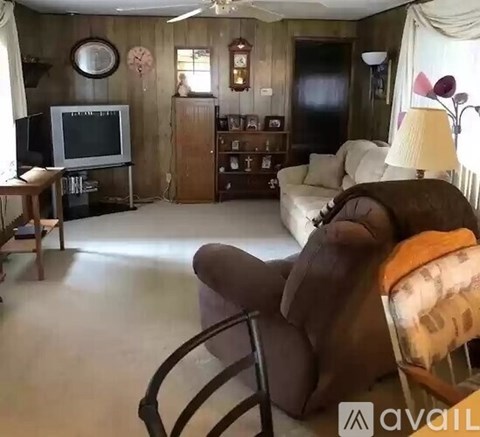 A living room with a brown leather chair in the foreground.