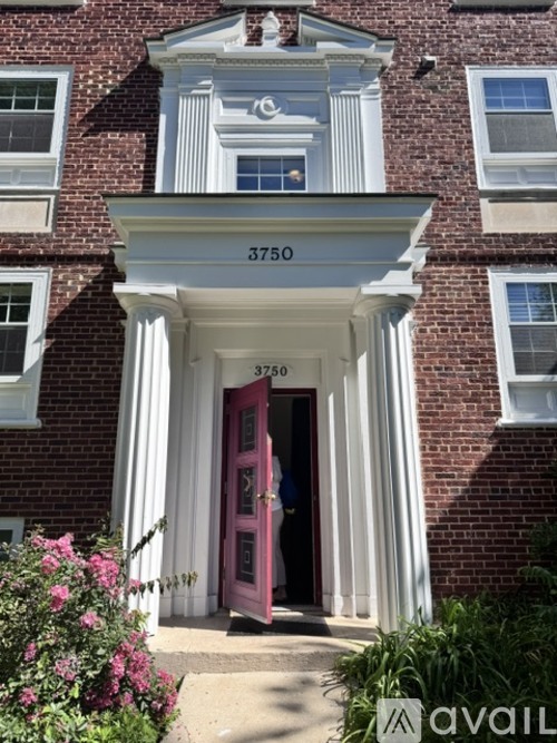 A red door is open to a white building with a number 3750 on it.