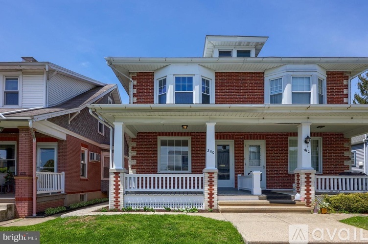 A red brick house with white trim and a porch.