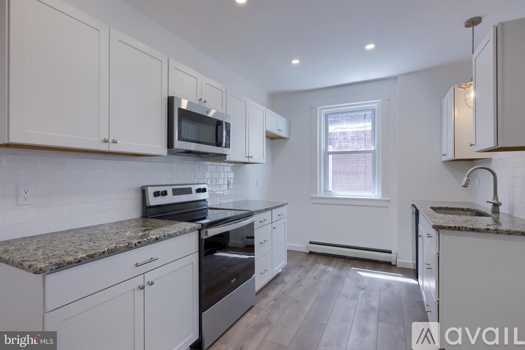 A kitchen with white cabinets and a granite countertop.