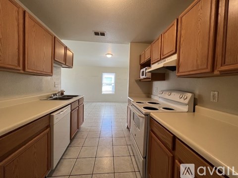 A kitchen with wooden cabinets and white appliances is available for rent.