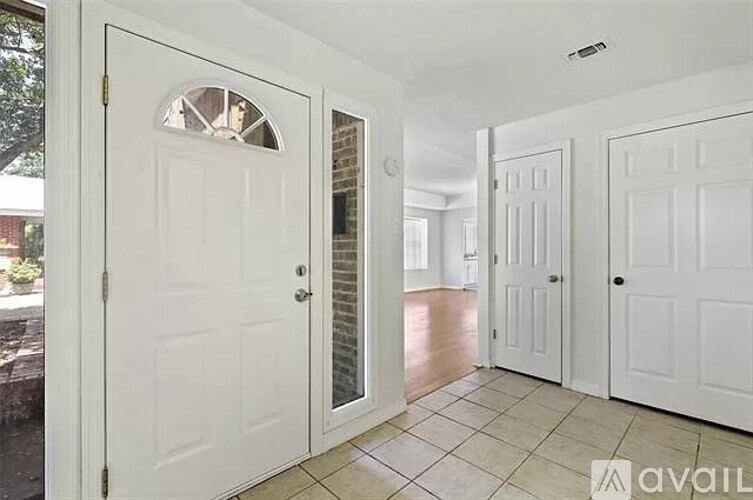 A white door with a window in the middle is open.