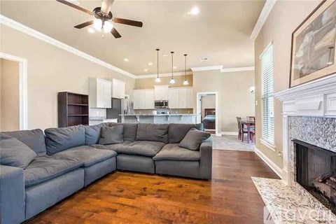 A living room with a grey sectional sofa and a fireplace.