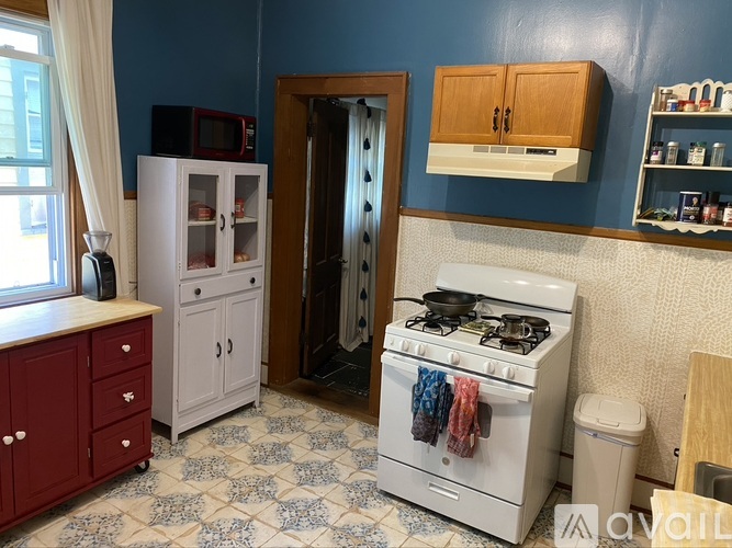 A kitchen with a white gas stove and a white refrigerator.