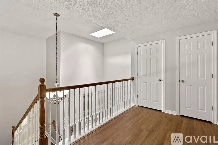 A room with a white door and a wooden staircase.
