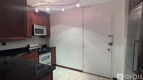 A kitchen with a black counter top and white appliances.
