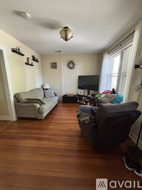A living room with a grey couch and a black chair.
