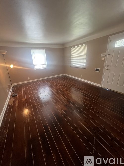 A room with wooden flooring and a window.
