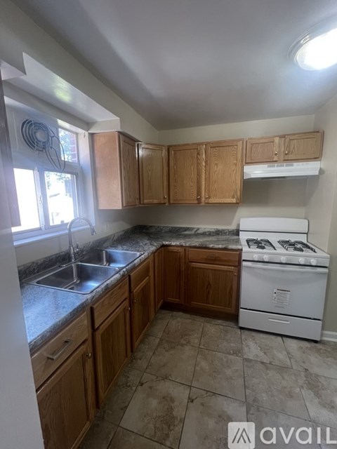 A kitchen with wooden cabinets and a white stove.