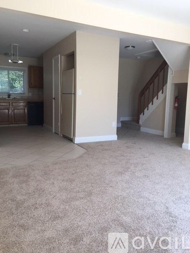 A living room with a staircase leading to the second floor.