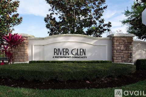 A sign that says River Glen in front of a tree.
