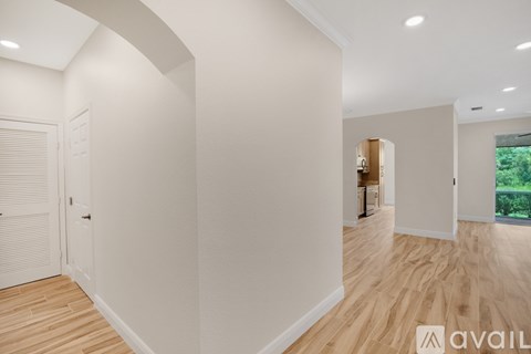 A spacious room with wooden flooring and white walls.