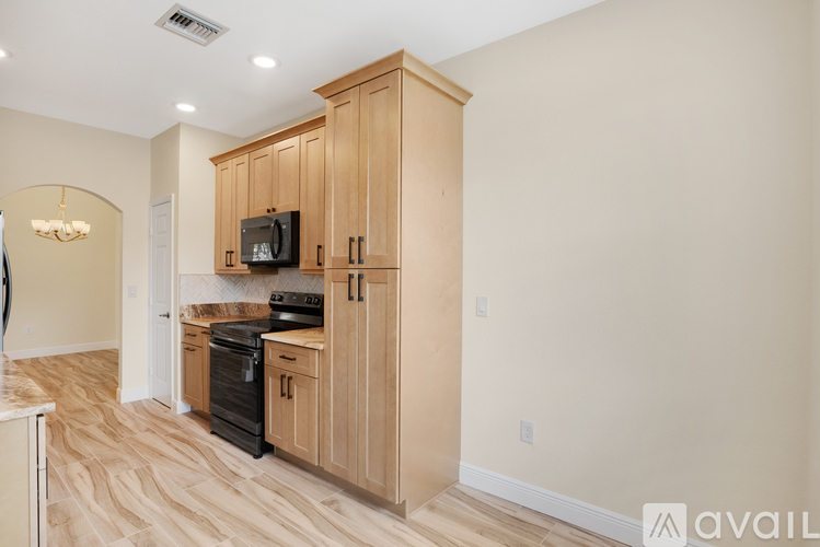 A kitchen with wooden cabinets and a black stove top oven.