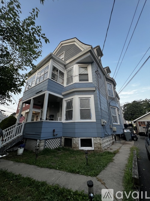 A blue house with a white picket fence in front.