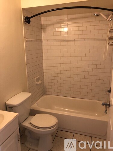 A white toilet sits next to a bathtub in a bathroom.