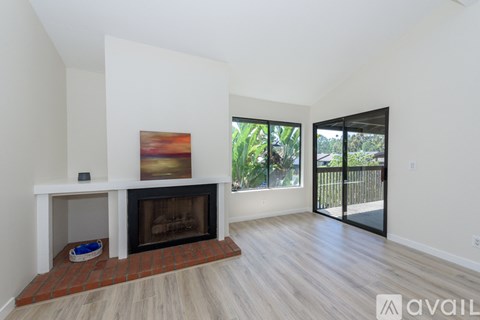 A living room with a fireplace and a painting on the wall.