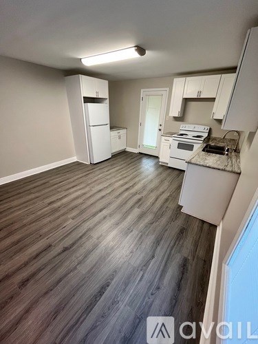 A kitchen with white appliances and cabinets is shown.