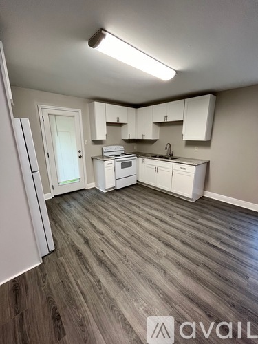 A kitchen with white appliances and cabinets.