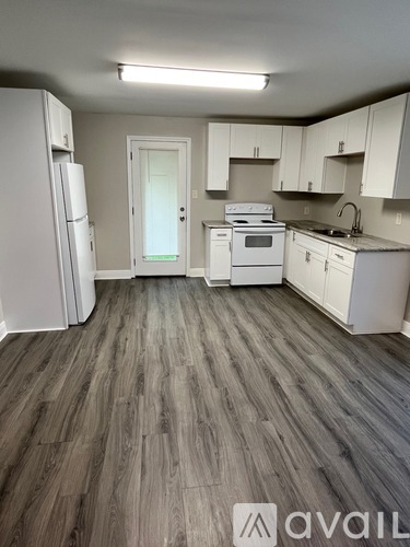 A kitchen with white appliances and cabinets.