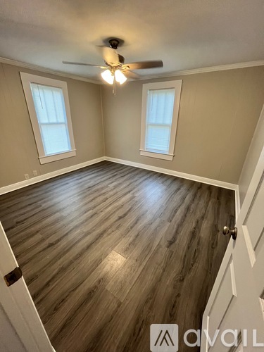 A room with wooden flooring and a ceiling fan.