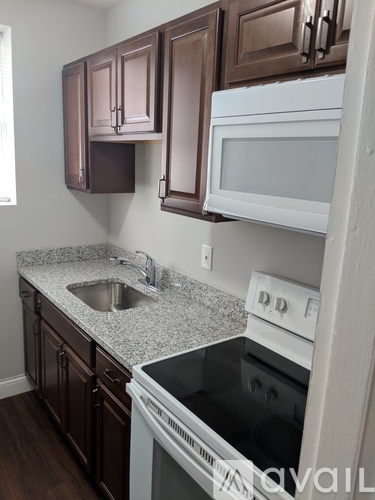 A kitchen with brown cabinets and white appliances.