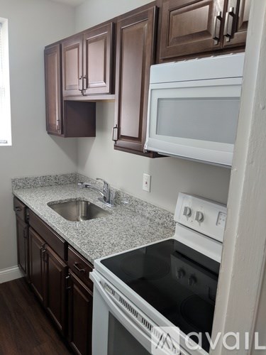 A kitchen with brown cabinets and white appliances.