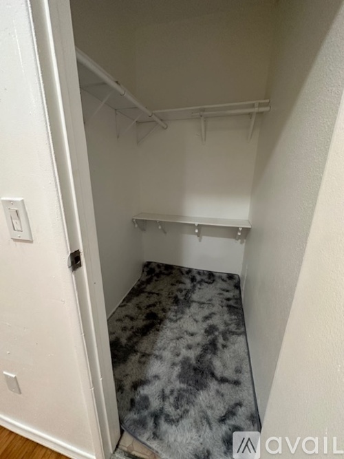 A small bedroom with a bed and a hanging closet rod.
