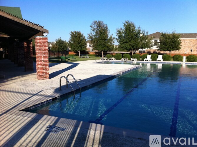 A pool with a diving board and a brick pillar.