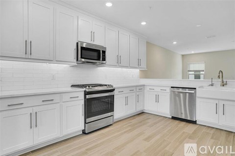 A kitchen with white cabinets and a microwave above the stove.