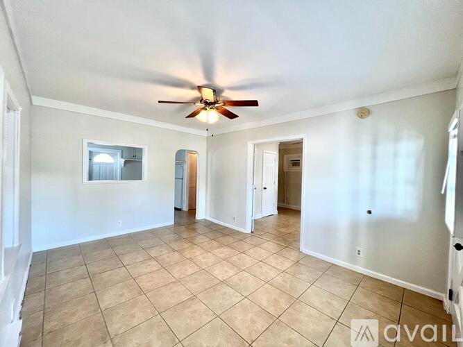 A spacious room with a ceiling fan and tiled floor.