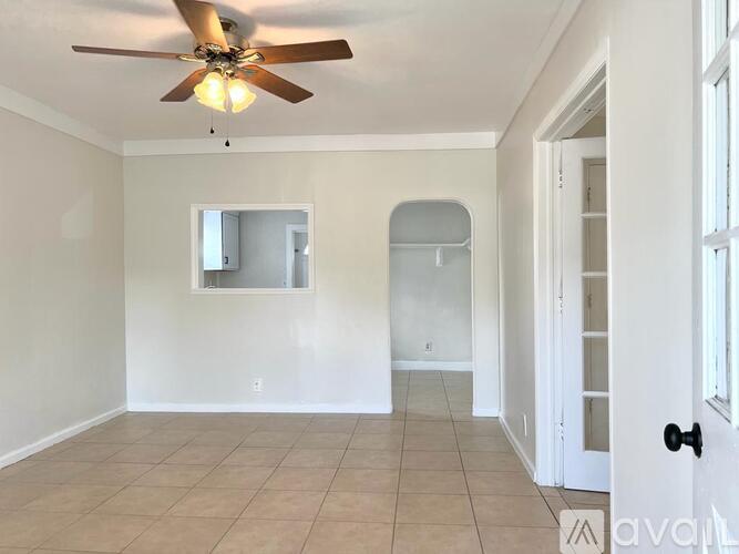 A room with a ceiling fan and tiled floor.