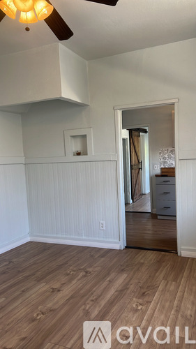A room with wooden flooring and a ceiling fan.