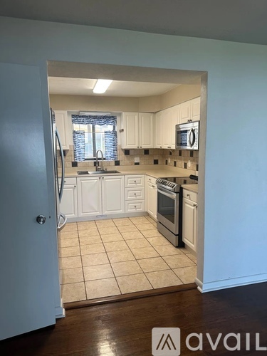 A kitchen with white cabinets and a tile floor.