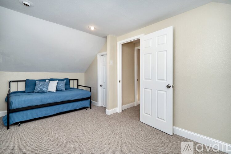 A bedroom with a bed and a carpeted floor.