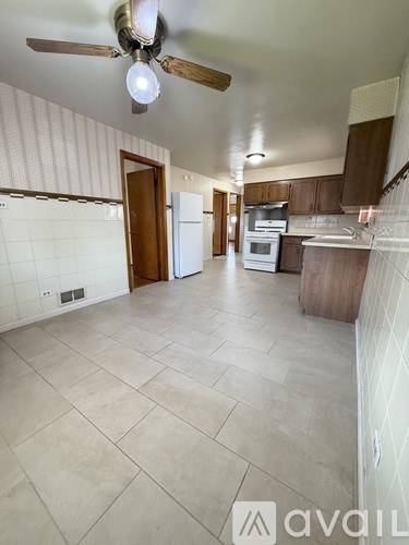 A kitchen with a fan and a tiled floor.