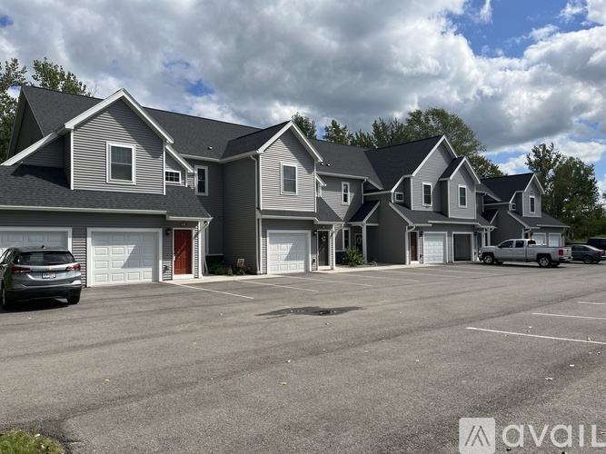 A row of houses with a car parked in front of the first house.