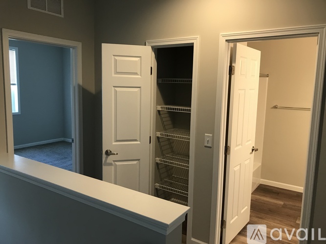 A room with a white door and a white cabinet with shelves.