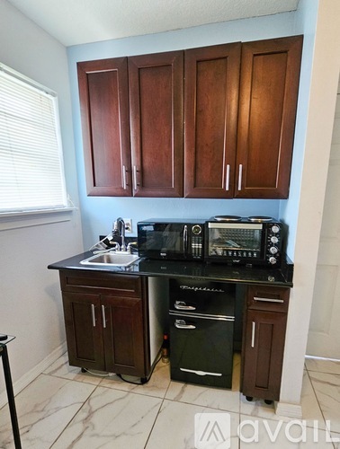 A kitchen with brown cabinets and black countertops.