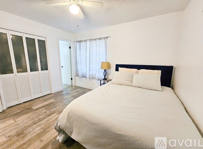 A bedroom with a large bed and a ceiling fan.