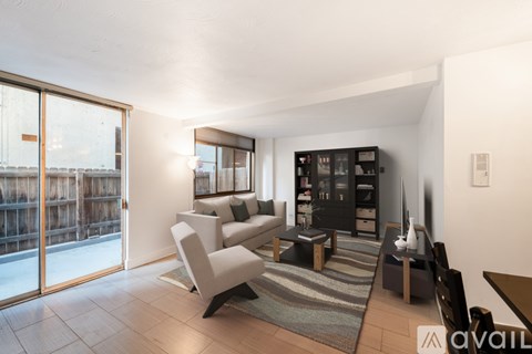 A living room with a white couch and a black bookshelf.