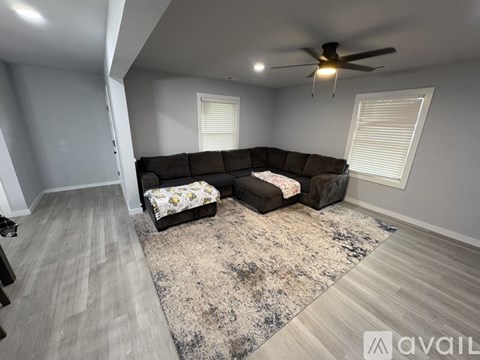A living room with a large sectional sofa and a rug.