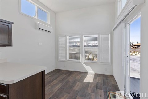 A room with a window and a wooden floor.