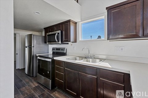 A kitchen with brown cabinets and stainless steel appliances.