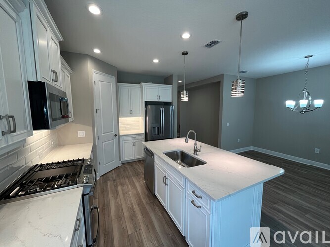 A kitchen with white cabinets and a large island.