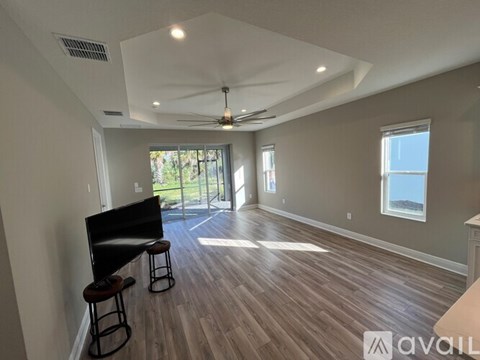 A living room with a television and a bar stool.